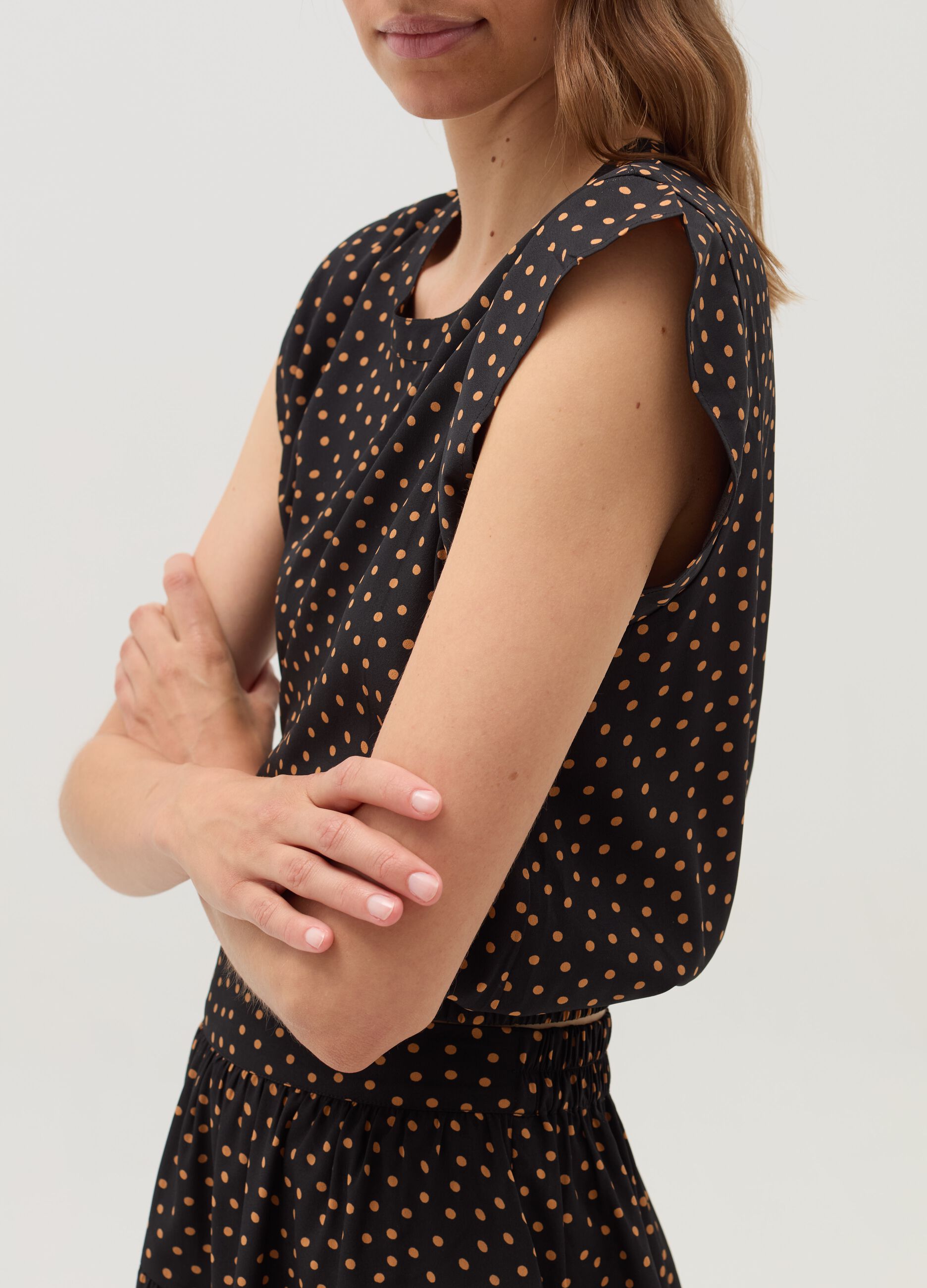 Sleeveless blouse with patterned flounce