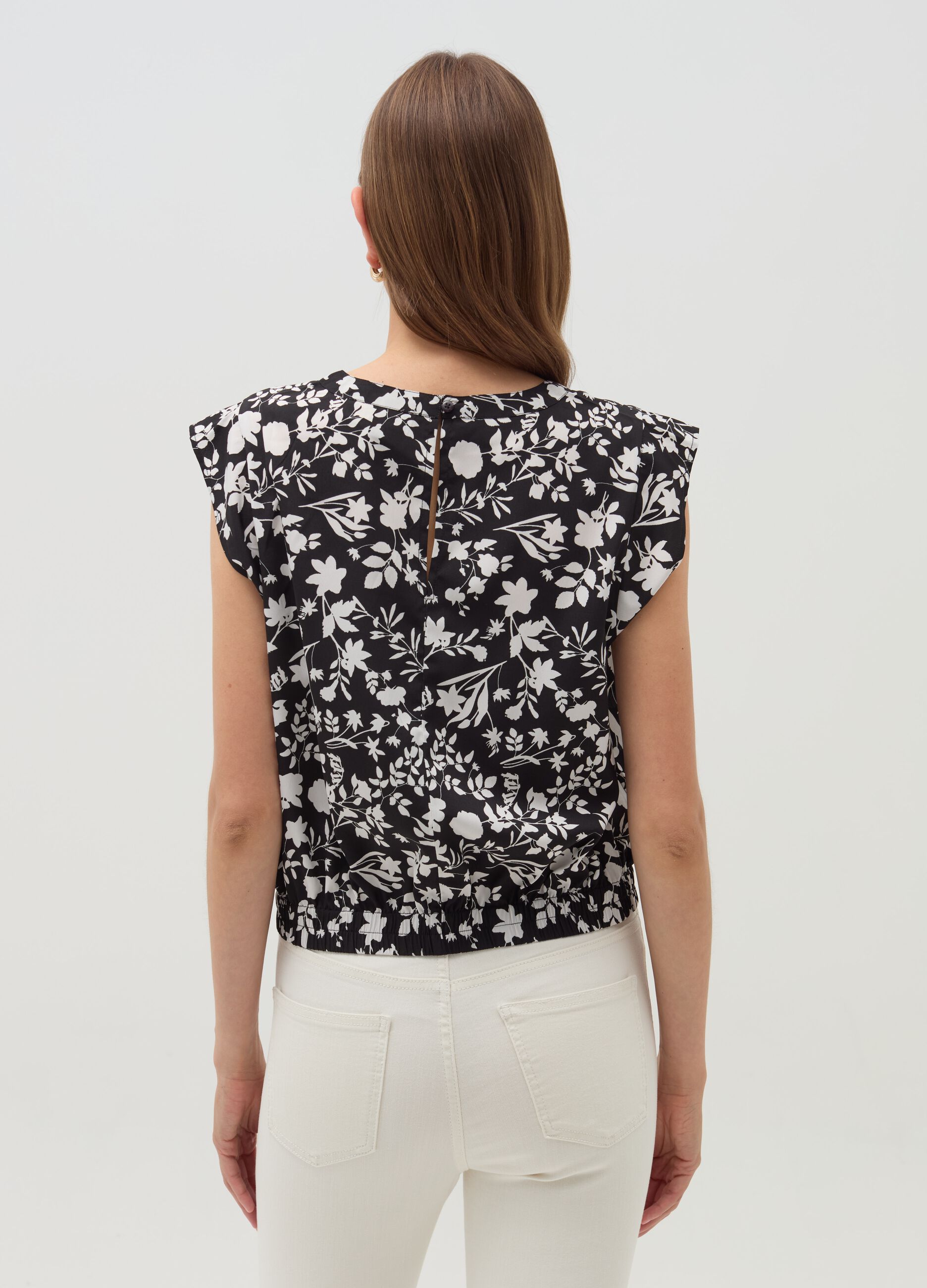 Sleeveless blouse with patterned flounce