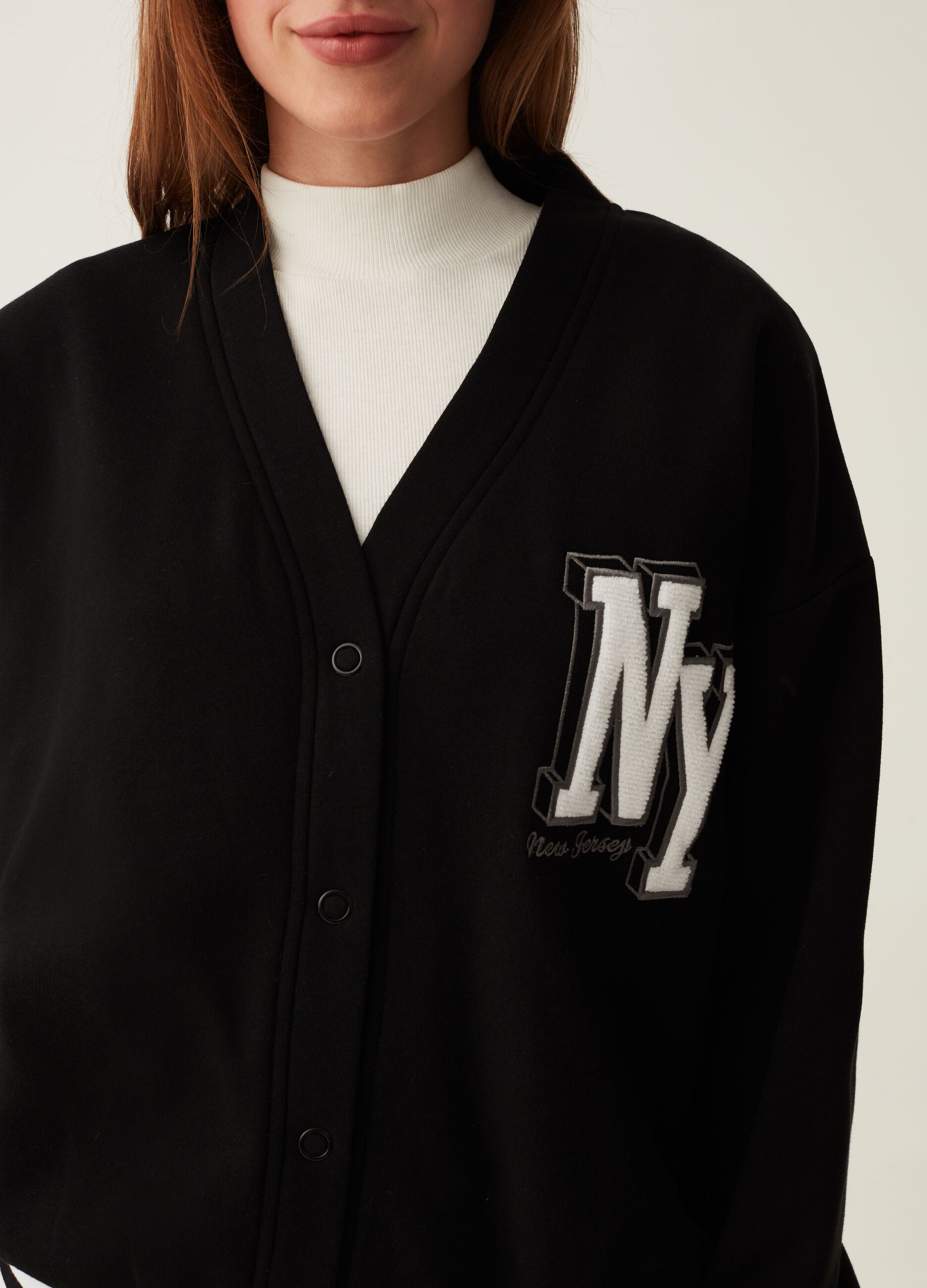 Varsity cardigan in plush with college emblem