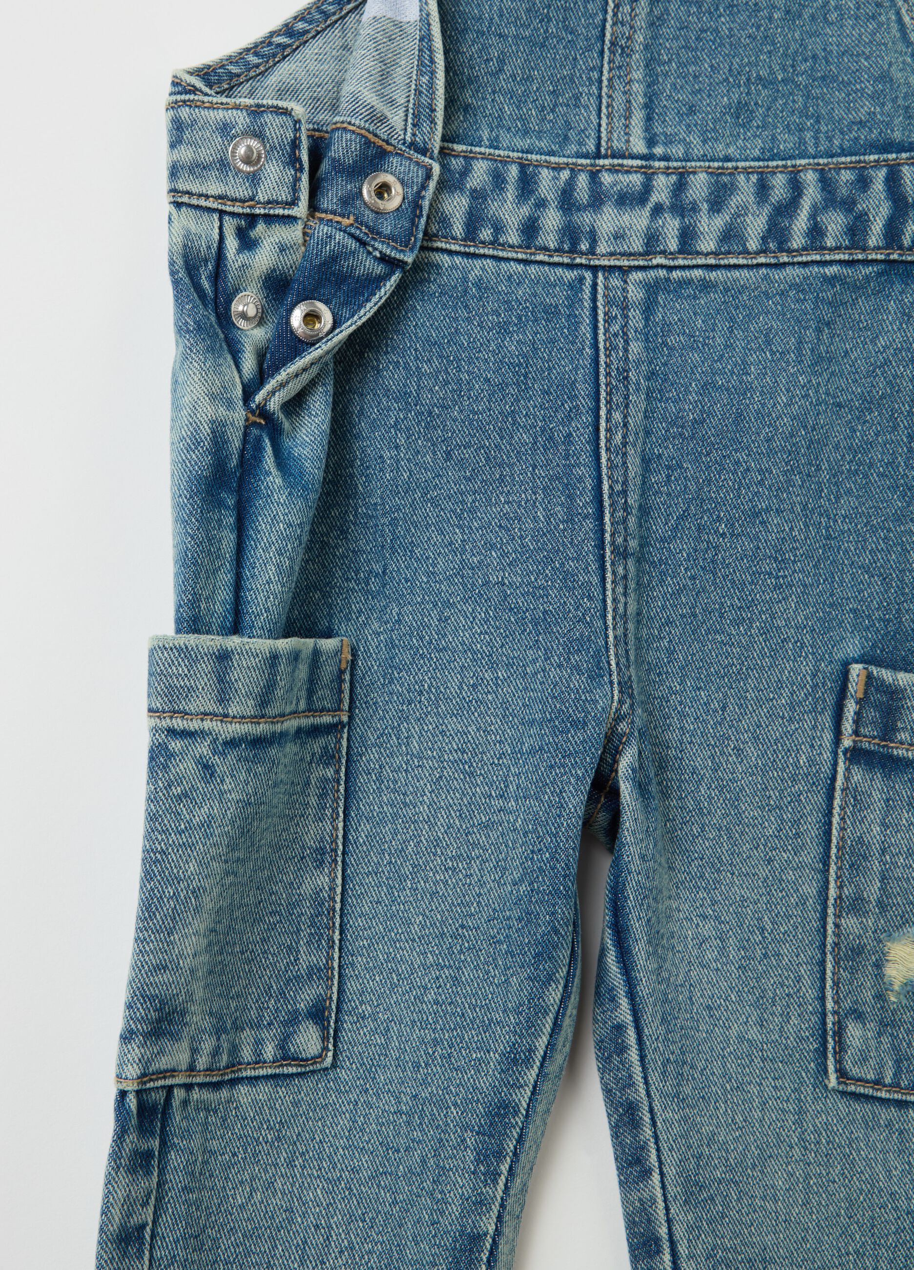 Denim dungarees with abrasions