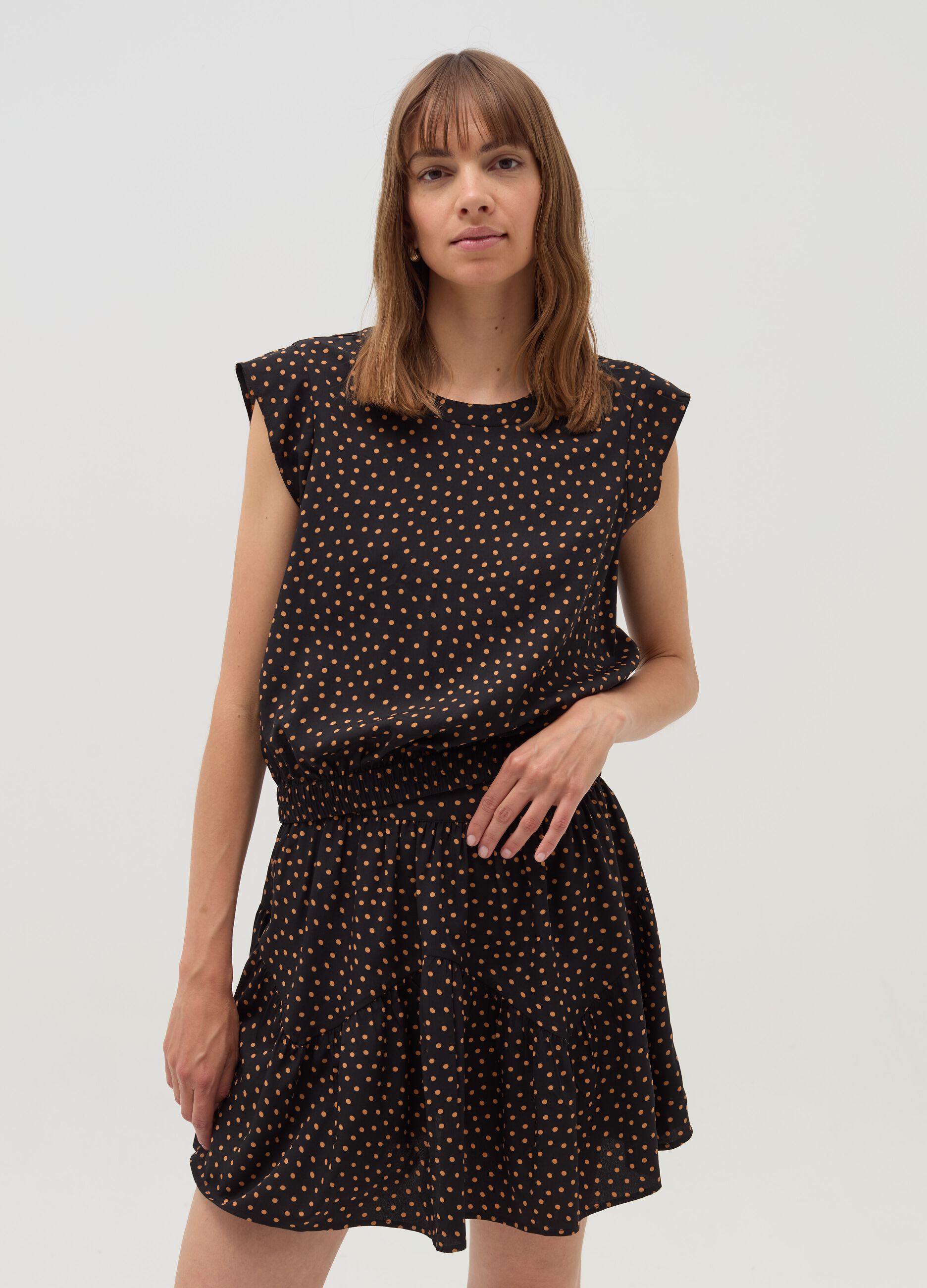 Sleeveless blouse with patterned flounce