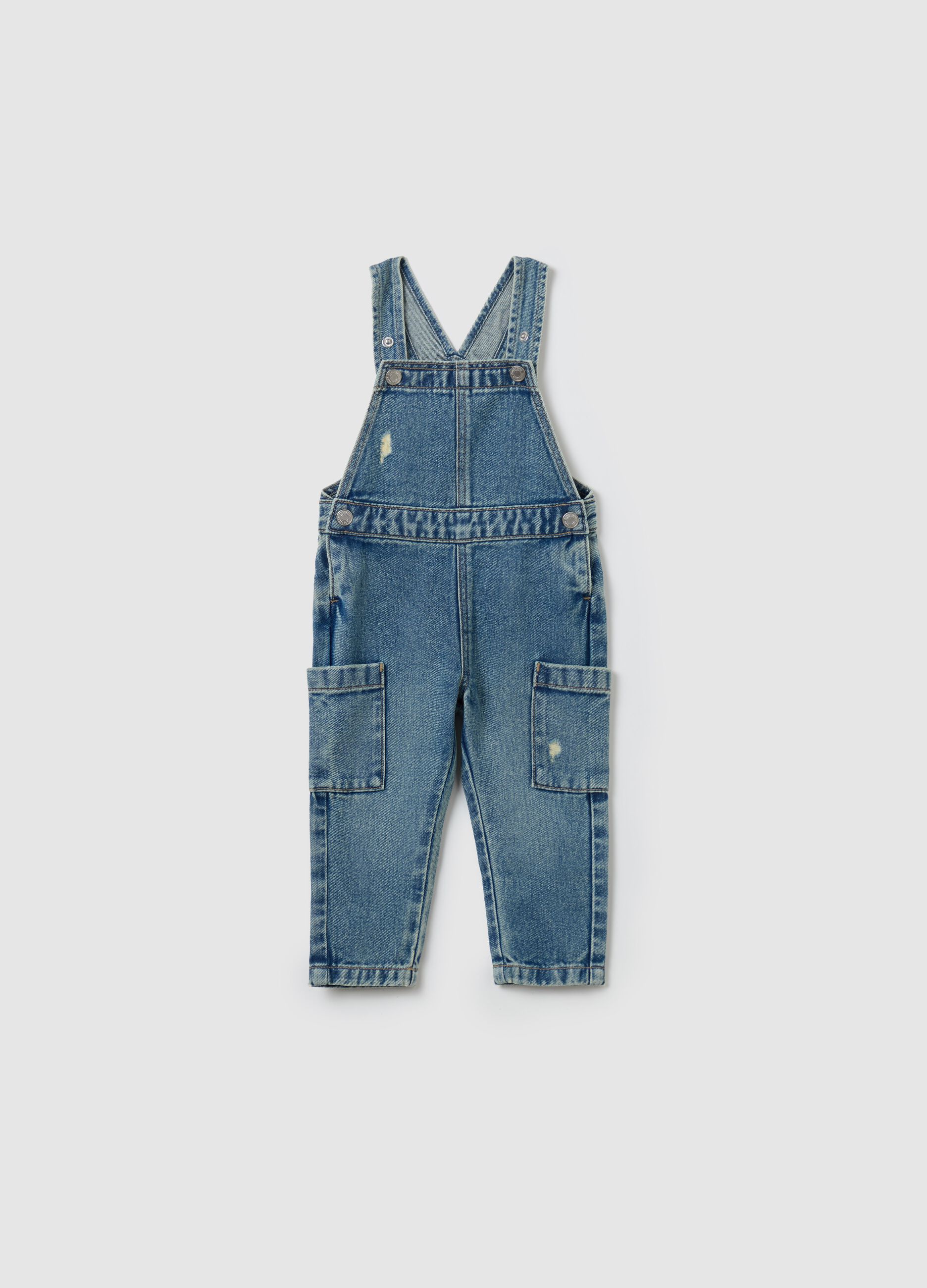 Denim dungarees with abrasions