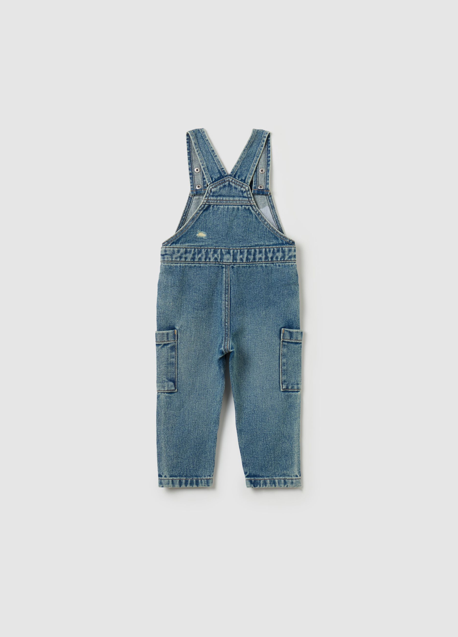 Denim dungarees with abrasions